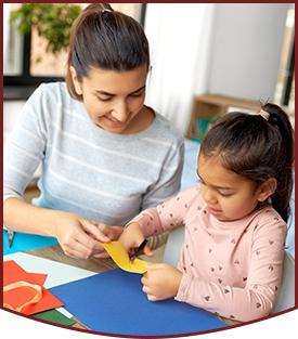 Teacher working with engaged kindergarten student at a table